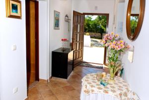 a room with a table with a vase of flowers on it at House Soni - 800 m from the sea in Rovinj