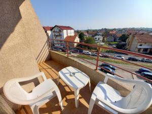 a balcony with two chairs and a table and a view at Venus Apartman in Brčko