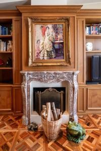 a living room with a fireplace with a painting above it at panoramic luxury penthouse 6 people in Milan