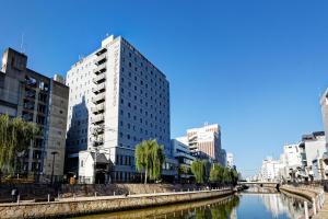 a tall building next to a river with buildings at Hakata Nakasu Washington Hotel Plaza in Fukuoka