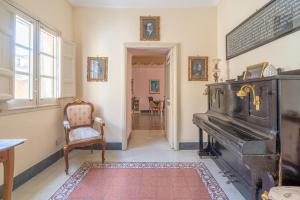 - un salon avec un vieux piano et une chaise dans l'établissement Casa De Rollo - Whole House, à Noto