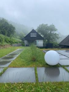 a house with a large white ball on the grass at Chata Patykowo in Myślenice