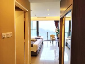 Habitación de hotel con 2 camas y balcón en GentingTop YinYangSuite6Pax @GrdIonDelmn en Genting Highlands