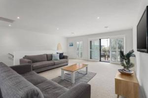 Golf Beach Retreat Torquay في توركوي: غرفة معيشة مع أريكة وطاولة