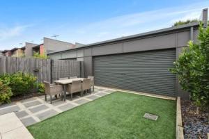 a small backyard with a table and a garage at Golf Beach Retreat Torquay in Torquay