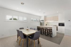 Golf Beach Retreat Torquay في توركوي: مطبخ وغرفة طعام مع طاولة وكراسي