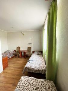 een kamer met twee bedden en een tafel erin bij Motel in Hoshcha