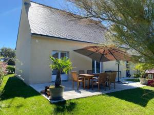 內韋的住宿－maison de vacances ninette，一个带桌子和遮阳伞的庭院