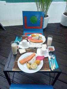 une table avec des assiettes de nourriture, de boissons et de lait dans l'établissement Moemoea Lodge, à Ambatoloaka