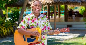 Ein Mann in einem hawaiianischen Hemd spielt Gitarre in der Unterkunft Navutu Stars Resort in Matayalevu