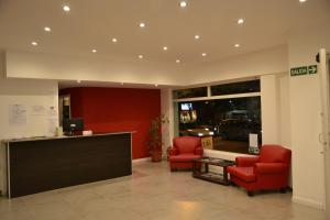a lobby with two red chairs and a reception desk at Hotel Astro in Mar del Plata