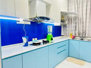 a blue and white kitchen with blue cabinets at ML Homestay in Kampung Seelung