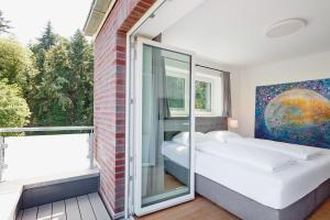 two beds in a room with a window at Apartmenthaus Emily by POLY Hohwacht in Hohwacht