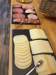 a table topped with different types of cheese and meats at Stadthotel Im Kolpinghaus in Werne an der Lippe