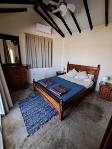 a bedroom with a large bed with a blue blanket at Sunset Retreat Cyprus in Pendakomo +14 photos