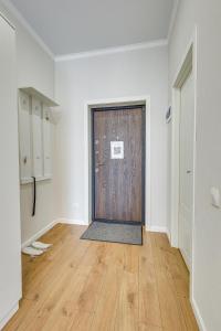 Pokój z drewnianymi drzwiami w białym pokoju w obiekcie Asaapart Lamiya 3-74 w mieście Ałma-Ata