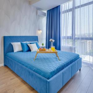 niebieskie łóżko w pokoju ze stołem w obiekcie Asaapart Lamiya 3-74 w mieście Ałma-Ata