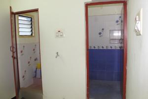 a bathroom with a shower with a blue wall at Centaurus Homestay near Trichy Airport in Tiruchchirāppalli