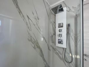 baño con ducha de cristal con fotografías en la pared en Novecento Luxury&Spa Residence 4 Stelle, en Montese 48 fotos más