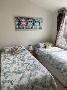 a bedroom with two beds and a window at 23 Ocean View Mullacott Park in West Down