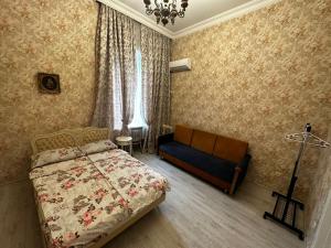 een slaapkamer met een bed en een bank erin bij STEPROOMS in Tbilisi City