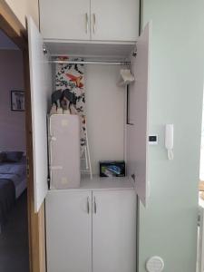 a small kitchen with white cabinets and a refrigerator at Apartament Wałowa in Wejherowo +13 photos