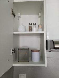 a kitchen with white shelves and a trash can at Apartament Wałowa in Wejherowo