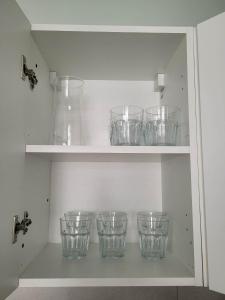 a shelf filled with glass bowls and vases at Apartament Wałowa in Wejherowo