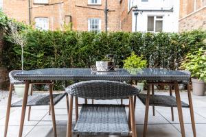 a table and chairs sitting on a patio at Elizabeth Mews - By Luxury Apartments in Cheltenham