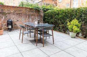 een tafel en stoelen op een patio bij Elizabeth Mews - By Luxury Apartments in Cheltenham