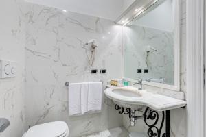 a white bathroom with a sink and a toilet at Hotel Cellini in Rome