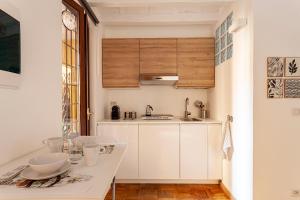 eine kleine Küche mit weißen Schränken und einem Tisch in der Unterkunft Appartamento Porta Ticinese - Navigli in Mailand