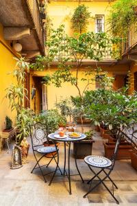 eine Terrasse mit einem Tisch, Stühlen und Pflanzen in der Unterkunft Appartamento Porta Ticinese - Navigli in Mailand