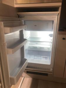 - un réfrigérateur vide avec une porte ouverte dans la cuisine dans l'établissement Appartement 1 chambre De Haan, au Coq