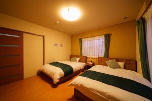 een hotelkamer met 2 bedden en een raam bij Yuki-an Bettei - Vacation STAY 86836 in Yufu