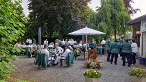 eine Gruppe von Menschen, die an Tischen im Garten sitzen in der Unterkunft Stadthotel Im Kolpinghaus in Werne an der Lippe