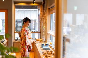 上越的住宿－‐izen 高田‐ 多賀，站在商店柜台前的妇女