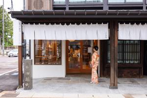 上越的住宿－‐izen 高田‐ 多賀，站在商店外的和服上的女人