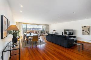 een woonkamer met een zwarte bank en een tafel bij Ocean Front 4-bed Luxury w/ Terrace & Parking in Matosinhos