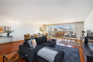 Ocean Front 4-bed Luxury w/ Terrace & Parking في ماتوسينهوس: غرفة معيشة مع أريكة وغرفة طعام