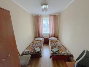 een kamer met 2 bedden en een raam bij Motel in Hoshcha