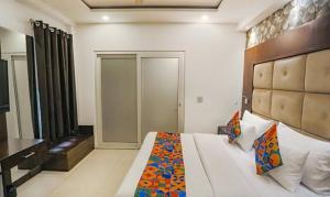 een slaapkamer met een groot wit bed in een kamer bij FabHotel Station I in New Delhi
