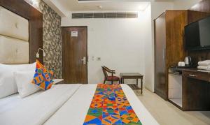 een hotelkamer met een bed met een kleurrijke deken bij FabHotel Station I in New Delhi