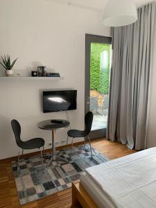 1 dormitorio con 2 sillas, 1 mesa y 1 cama en Apartment Talblick en Kandern