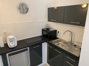 a small kitchen with a sink and a microwave at Apartment Talblick in Kandern