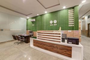 an office with a green wall and a desk at OYO Flagship THE HOSTEL YARD in Noida