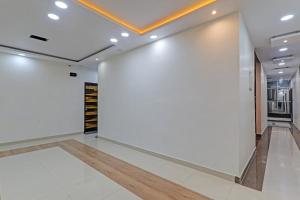 a large white wall in a room with white tiles at Super Collection O Oyo Townhouse Lemonade Shyam Nagar in Juhi Bari