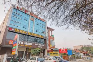 un edificio con coches estacionados frente a él en Super Collection O Oyo Townhouse Lemonade Shyam Nagar, en Juhi Bari