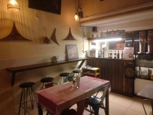 a dining room with a table and bar with stools at TaSahin Hostel & Turkish Restaurant & Bar in Phnom Penh