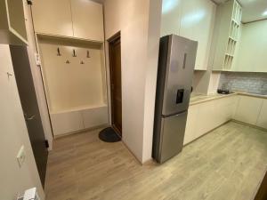 a kitchen with a stainless steel refrigerator in a room at Dani Apartment in Kutaisi